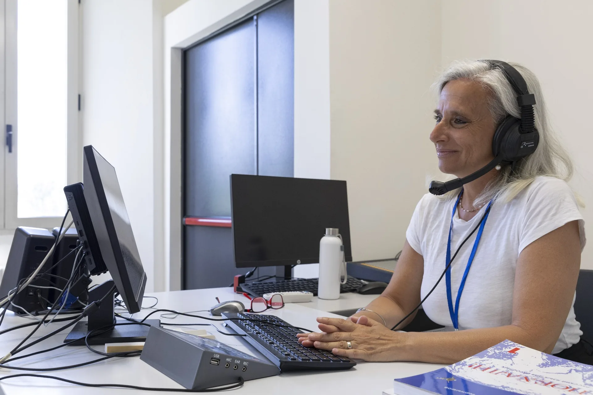 A teacher with headset at the computer in the language lab